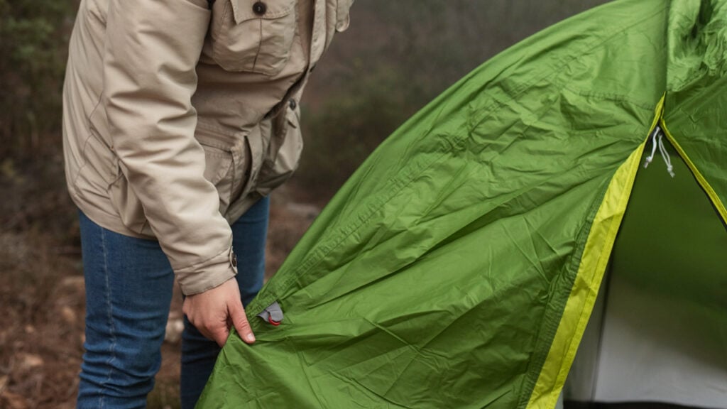 man inspecting tent